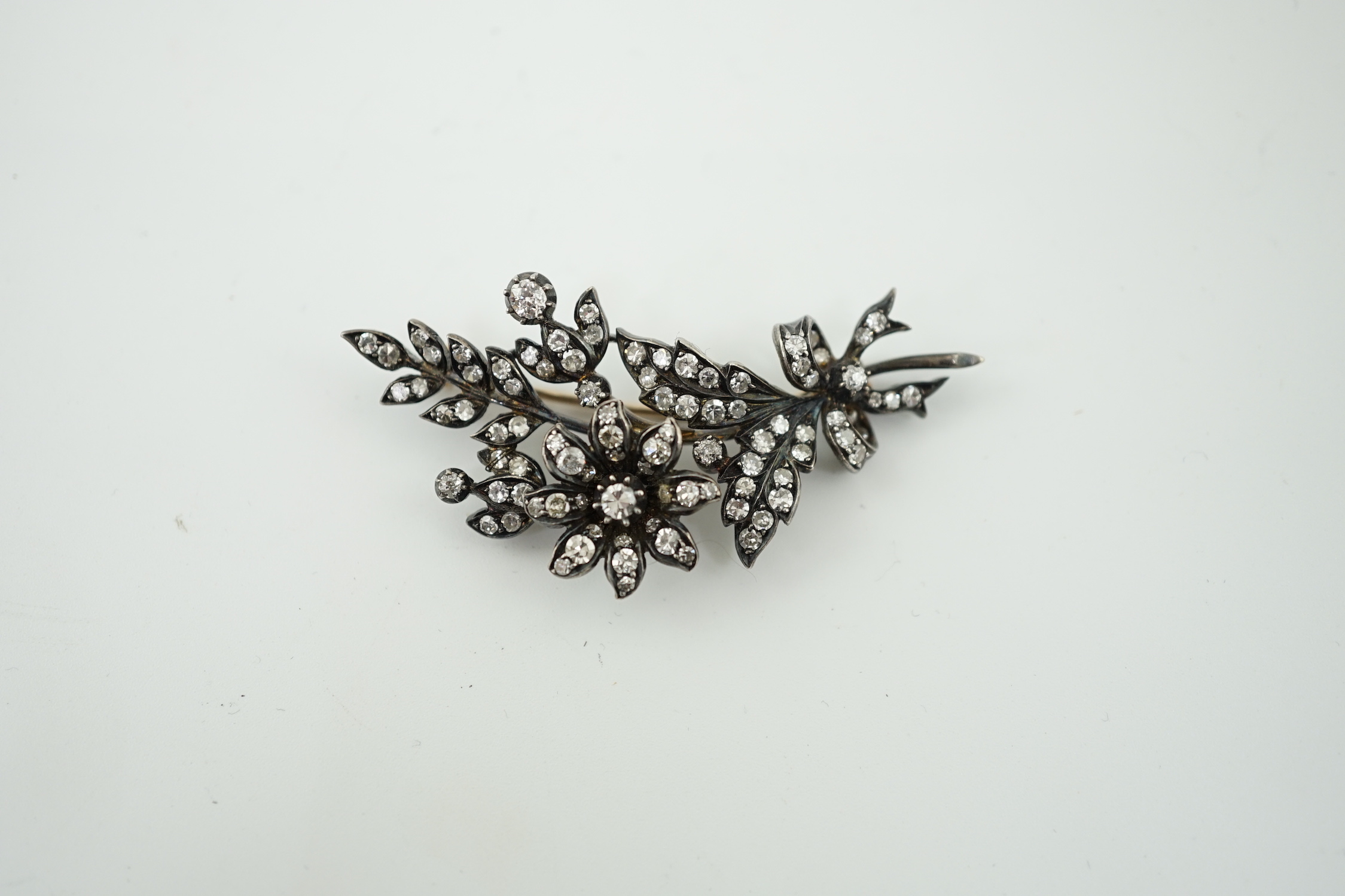 A late Victorian gold, silver and diamond cluster set trembleuse floral spray brooch